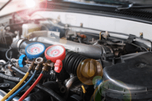 Car a/c repair, auto repair in Merriam, KS, at Done With Care Auto Repair. An image of professional automotive A/C manifold gauges connected to a vehicle during air conditioning diagnostics, refrigerant pressure testing, and A/C repair service.