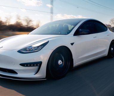Adas Calibration, Tesla Repair, Hybrid/EV Repair In Merriam, KS At Done With Care Auto Repair. Tesla Model 3 driving on a road in Merriam, KS